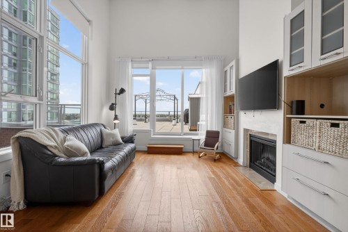 Expansive living area featuring soaring ceilings and wood-finish flooring - 808 2612 109 Street, Edmonton, AB - Indoor Photo Showing Living Room With Fireplace