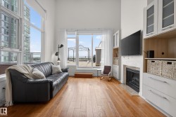 Expansive living area featuring soaring ceilings and wood-finish flooring - 