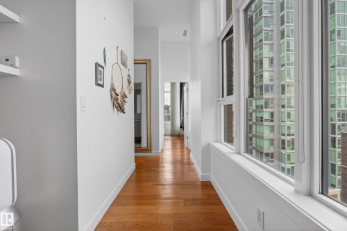 Hallway with wood-finish flooring, white baseboards, and a series of large windows - 808 2612 109 Street, Edmonton, AB - Indoor Photo Showing Other Room