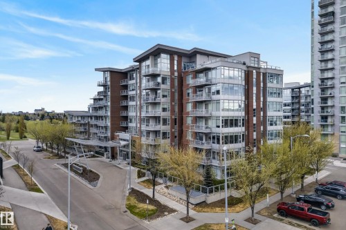Modern multi-story building featuring brick and glass facades, multiple balconies with glass railings, a covered entry, and a paved driveway - 808 2612 109 Street, Edmonton, AB - Outdoor With Facade