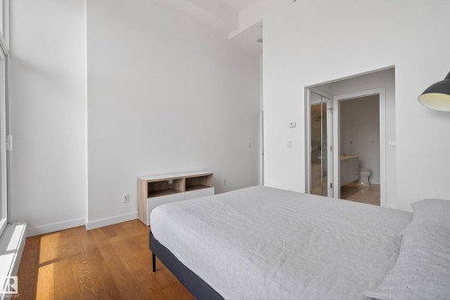 Hardwood flooring and high ceilings characterize this bedroom space - 808 2612 109 Street, Edmonton, AB - Indoor Photo Showing Bedroom