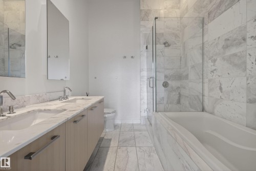 Contemporary bathroom featuring a light wood-finish double vanity with undermount sinks, chrome fixtures, and a white countertop - 808 2612 109 Street, Edmonton, AB - Indoor Photo Showing Bathroom