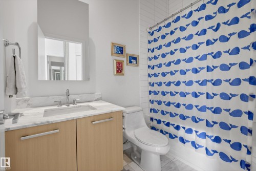 Bathroom featuring a light wood-finish vanity with a stone countertop, an undermount sink, and chrome fixtures - 808 2612 109 Street, Edmonton, AB - Indoor Photo Showing Bathroom