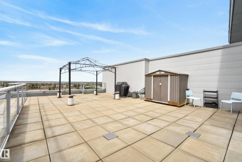 Expansive rooftop patio featuring large format paver tiles, a metal gazebo frame, and a storage shed - 808 2612 109 Street, Edmonton, AB - Outdoor With Exterior