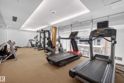 Fitness room featuring cardio equipment, strength training machines, ample natural light from floor-to-ceiling windows, recessed lighting, and textural column accents - 808 2612 109 Street, Edmonton, AB - Indoor Photo Showing Gym Room