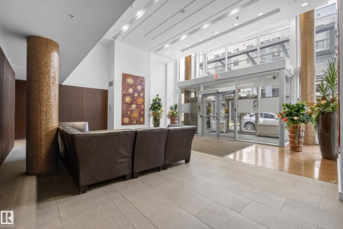 Contemporary lobby featuring a glass entry system with automatic doors, high ceilings, and recessed lighting - 808 2612 109 Street, Edmonton, AB - Indoor Photo Showing Other Room