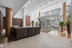 Contemporary lobby featuring a glass entry system with automatic doors, high ceilings, and recessed lighting - 