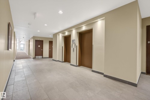 Building hallway featuring two elevators with matching bronze doors, recessed lighting, and light-toned rectangular tile flooring - 808 2612 109 Street, Edmonton, AB - Indoor Photo Showing Other Room