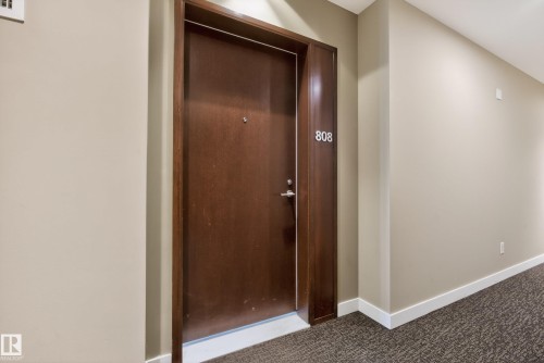 Solid wood-panel entry door with contrasting trim - 808 2612 109 Street, Edmonton, AB - Indoor Photo Showing Other Room