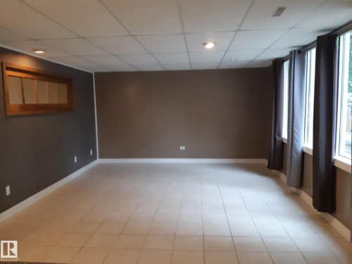 Spacious living room with light-toned tile flooring, recessed lighting, and multiple windows - 3809 112 Avenue, Edmonton, AB - Indoor Photo Showing Other Room
