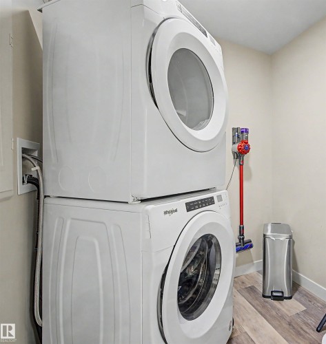 Dedicated laundry area featuring stacked front-loading washer and dryer units - 209 1029 173 Stnw, Edmonton, AB - Indoor Photo Showing Laundry Room