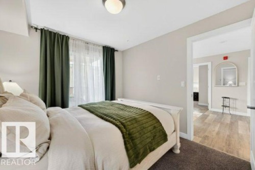 Carpeted bedroom with a white bed frame and a semi-flush mount ceiling light - 209 1029 173 Stnw, Edmonton, AB - Indoor Photo Showing Bedroom