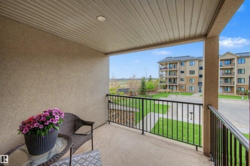 Private balcony with textured exterior wall, concrete flooring, and black metal railings - 209 1029 173 Stnw, Edmonton, AB - Outdoor With Balcony With Exterior