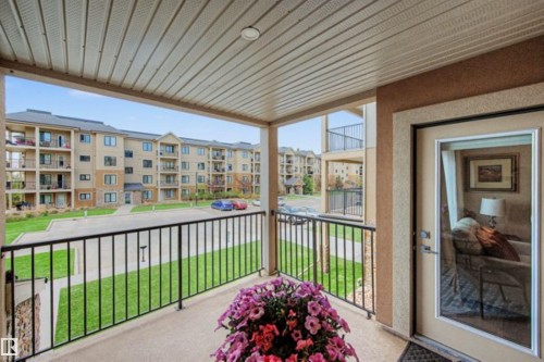 Covered balcony with a textured concrete floor and black metal railings - 209 1029 173 Stnw, Edmonton, AB - Outdoor With Balcony With Exterior