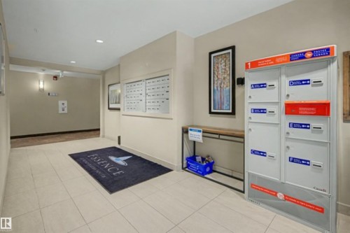 Building common area featuring large format tile flooring, recessed lighting, individual mailboxes, and parcel lockers - 209 1029 173 Stnw, Edmonton, AB - Indoor