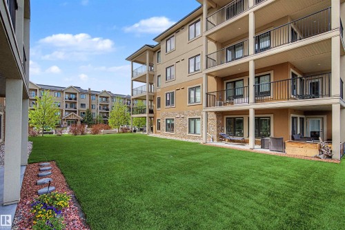 Expansive green space featuring a manicured lawn and landscaping with decorative stepping stones - 209 1029 173 Stnw, Edmonton, AB - Outdoor With Balcony