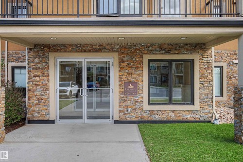 Building exterior featuring stone veneer siding, stucco accents, and a covered entrance - 209 1029 173 Stnw, Edmonton, AB - Outdoor With Balcony