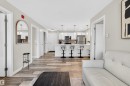 Open-concept living space featuring wood-finish flooring, recessed lighting, and a neutral wall palette - 209 1029 173 Stnw, Edmonton, AB  - Indoor 