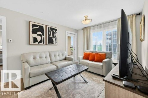 Living space featuring wood-finish flooring, light neutral wall paint, and a double window with blinds - 209 1029 173 Stnw, Edmonton, AB - Indoor Photo Showing Living Room