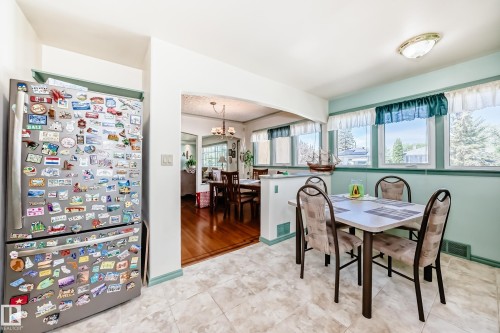 Dining area featuring a neutral tiled floor and light blue walls with a teal trim - 11309 115 Street, Edmonton, AB - Indoor Photo Showing Dining Room