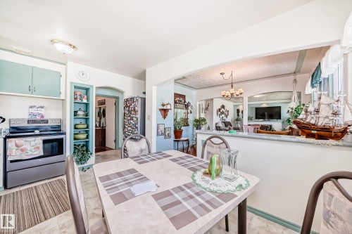 Eat-in kitchen featuring a built-in oven range, upper and lower cabinetry, and a pass-through opening to another room - 11309 115 Street, Edmonton, AB - Indoor