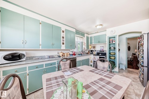 Kitchen featuring extensive cabinetry in a soft blue hue, white countertops, and durable flooring - 11309 115 Street, Edmonton, AB - Indoor