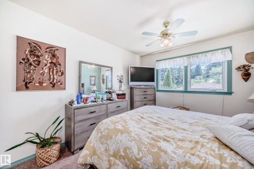 Bedroom featuring a ceiling fan with integrated lighting, dual windows with a green trim, and neutral wall tones - 11309 115 Street, Edmonton, AB - Indoor Photo Showing Bedroom
