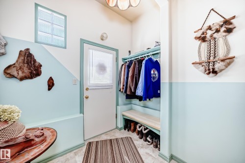 Entryway featuring a built-in bench with integrated shelving, overhead coat rack, and glass block window - 11309 115 Street, Edmonton, AB - Indoor