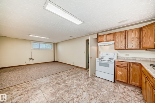 Kitchenette featuring wood cabinetry, laminate countertops, and a white electric range - 11309 115 Street, Edmonton, AB - Indoor Photo Showing Kitchen