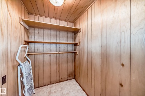 Utility room featuring wood-panel walls, built-in shelving, and a ceiling-mounted light fixture - 11309 115 Street, Edmonton, AB - Indoor Photo Showing Other Room