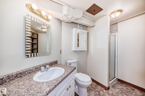 Bathroom featuring a vanity with an integrated sink, patterned countertop, and chrome faucet - 11309 115 Street, Edmonton, AB - Indoor Photo Showing Bathroom