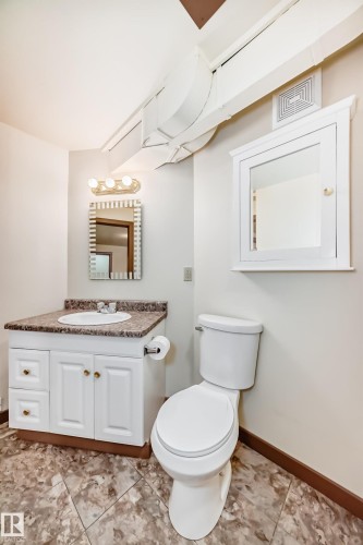 Bathroom featuring a white vanity with a built-in sink, patterned countertop, and gold-toned hardware - 11309 115 Street, Edmonton, AB - Indoor Photo Showing Bathroom