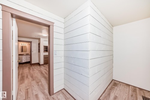 White shiplap wall paneling, wood-finish flooring, and painted trim - 11309 115 Street, Edmonton, AB - Indoor Photo Showing Other Room