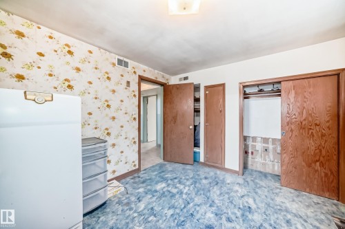 Spacious room featuring patterned wallpaper, blue-patterned flooring, and a flush-mount ceiling light fixture - 11309 115 Street, Edmonton, AB - Indoor Photo Showing Other Room