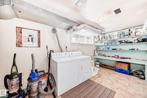 Utility room featuring light-colored walls, a tiled floor, and a window providing natural light - 11309 115 Street, Edmonton, AB - Indoor Photo Showing Laundry Room