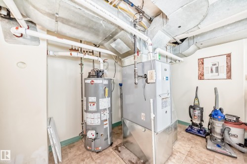 Utility room featuring a furnace, water heater, exposed ductwork, PVC piping, and tiled flooring - 11309 115 Street, Edmonton, AB - Indoor