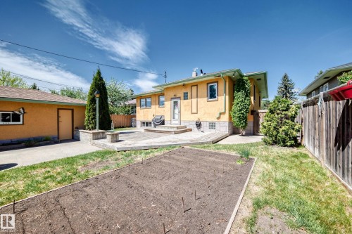 Expansive backyard featuring a large raised garden bed, concrete patio, and wood-finish deck - 11309 115 Street, Edmonton, AB - Outdoor