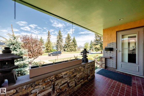 Inviting covered front porch with red tile flooring - 11309 115 Street, Edmonton, AB - Outdoor With Deck Patio Veranda