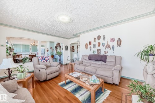 Hardwood flooring extending throughout, with a textured ceiling and decorative trim - 11309 115 Street, Edmonton, AB - Indoor Photo Showing Living Room
