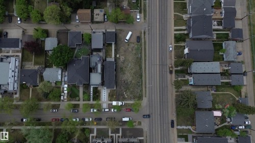 Aerial perspective showcasing a residential street with multiple properties featuring dark-toned roofs and varying lot sizes - 14039 104 Avenue Nw, Edmonton, AB 