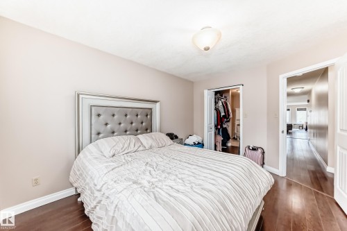 Bedroom featuring wood-finish flooring, a built-in closet with bi-fold doors, and a ceiling-mounted light fixture - 9110 180A Avenue, Edmonton, AB - Indoor Photo Showing Bedroom