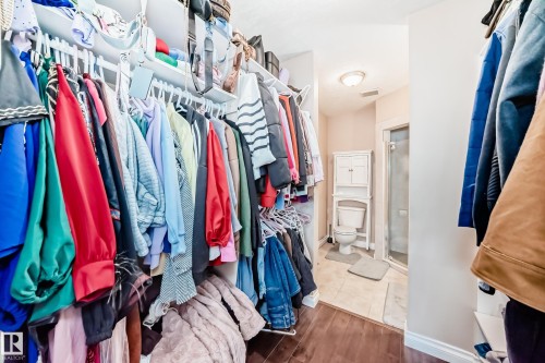 Walk-through closet with built-in shelving and hanging rods - 9110 180A Avenue, Edmonton, AB - Indoor With Storage