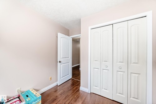 Interior featuring wood-finish flooring, light neutral wall paint, white trim, and a white bi-fold closet - 9110 180A Avenue, Edmonton, AB - Indoor