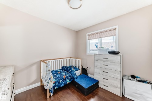 Hardwood-finish flooring complements neutral wall tones and white baseboards - 9110 180A Avenue, Edmonton, AB - Indoor Photo Showing Bedroom