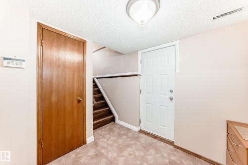 Interior space featuring wood-finish doors, a white paneled door, and a staircase with wooden treads - 9110 180A Avenue, Edmonton, AB - Indoor Photo Showing Other Room