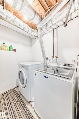Dedicated laundry area featuring a white front-load washing machine and a white top-load washing machine - 9110 180A Avenue, Edmonton, AB - Indoor Photo Showing Laundry Room