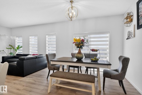 Open-concept living area with wood-finish flooring, recessed lighting, and a contemporary chandelier - 7011 177 Avenue, Edmonton, AB - Indoor Photo Showing Dining Room