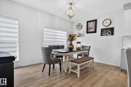 Dining area featuring light wood-finish flooring, white walls, and a contemporary ceiling fixture - 7011 177 Avenue, Edmonton, AB - Indoor Photo Showing Dining Room