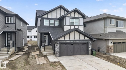 Contemporary two-story residence featuring a dark gray and white exterior with stone accents - 7011 177 Avenue, Edmonton, AB - Outdoor With Facade