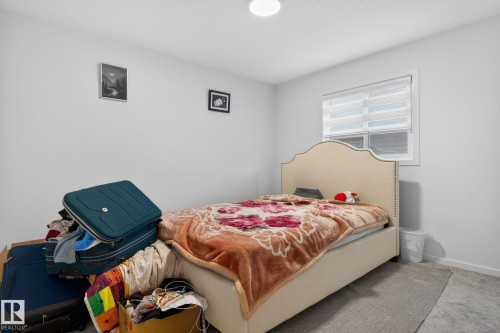 Neutral wall paint, light gray carpet flooring, recessed ceiling light, and a window with blinds - 7011 177 Avenue, Edmonton, AB - Indoor Photo Showing Bedroom